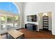 Bright living room featuring dark wood floors and sliding glass doors with plantation shutters at 620 Painted Cloud Pl, Las Vegas, NV 89144