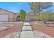 Attractive home featuring a tidy front yard with decorative rock and walkway at 7113 Carrondale Way, Las Vegas, NV 89128