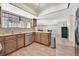 Open kitchen with wood cabinets, stainless steel appliances, and hardwood style floors looking into the dining area at 7113 Carrondale Way, Las Vegas, NV 89128