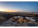 Expansive aerial view of a modern property on a hilltop, offering panoramic views of the Las Vegas skyline at 720 Dragon Peak Dr, Henderson, NV 89012