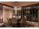 Elegant dining room featuring a glass table, stylish chairs, and a temperature-controlled wine storage at 720 Dragon Peak Dr, Henderson, NV 89012