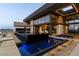Striking modern exterior with reflecting pool and expansive windows offering stunning views from this architectural gem at 720 Dragon Peak Dr, Henderson, NV 89012