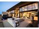 Modern home with floor-to-ceiling windows, inviting outdoor seating, and sleek fire pit feature at 720 Dragon Peak Dr, Henderson, NV 89012