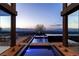 Striking view of the city skyline from the modern home's infinity pool and expansive windows at 720 Dragon Peak Dr, Henderson, NV 89012