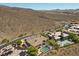 Aerial view showcasing a home with a pool and desert landscape, nestled against a mountain backdrop at 73 Kittansett Loop, Henderson, NV 89052