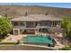 Aerial view of a house featuring a pool, patio, and desert landscaping, perfect for outdoor living at 73 Kittansett Loop, Henderson, NV 89052