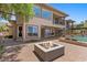 Wide backyard view highlighting the fire pit, pool, patio, and architecture of the luxury home at 73 Kittansett Loop, Henderson, NV 89052