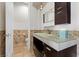 Chic bathroom with designer vanity, glass countertop, and tiled walls at 73 Kittansett Loop, Henderson, NV 89052