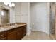 Well-appointed bathroom featuring dual sinks, granite countertops, and tiled shower with glass door at 73 Kittansett Loop, Henderson, NV 89052