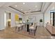 This virtually staged dining room features a modern chandelier, glass table, and stylish decor at 73 Kittansett Loop, Henderson, NV 89052