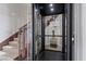 Modern home elevator with glass enclosure, adjacent to a carpeted staircase at 73 Kittansett Loop, Henderson, NV 89052