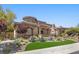 Beautiful stucco single-Gathering home featuring lush landscaping, a stone accent, and manicured lawn at 73 Kittansett Loop, Henderson, NV 89052
