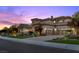 Stunning home featuring a three-car garage, well-manicured landscaping, and a driveway at dusk at 73 Kittansett Loop, Henderson, NV 89052