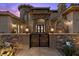 Grand entrance with decorative iron gate, stone pillars, and exterior lighting at 73 Kittansett Loop, Henderson, NV 89052