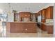 Spacious kitchen with rich wood cabinetry, granite countertops, and stainless steel appliances at 73 Kittansett Loop, Henderson, NV 89052