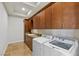 Functional laundry room with granite countertops, built-in cabinetry, a sink, and modern washing machine and dryer at 73 Kittansett Loop, Henderson, NV 89052