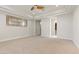 Spacious main bedroom featuring carpet, tray ceiling, ceiling fan, and an ensuite bathroom at 73 Kittansett Loop, Henderson, NV 89052