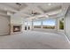 Spacious primary bedroom with a fireplace, coffered ceiling, and large windows showcasing scenic views at 73 Kittansett Loop, Henderson, NV 89052