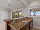 Stylish wet bar with granite countertop and wooden cabinetry near the outdoor patio at 73 Kittansett Loop, Henderson, NV 89052