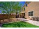 This backyard has a small lawn and a brick patio with outdoor seating and a built-in barbecue at 7733 Harthill Park Ave, Las Vegas, NV 89113