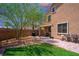 This backyard has a small lawn and a brick patio with outdoor seating and a built-in barbecue at 7733 Harthill Park Ave, Las Vegas, NV 89113