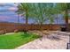 Enjoy the outdoor living space featuring a brick patio, lawn, and mature landscaping in this backyard at 7733 Harthill Park Ave, Las Vegas, NV 89113