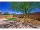 Private backyard featuring a paved patio, lush lawn, and desert landscaping at 7733 Harthill Park Ave, Las Vegas, NV 89113