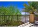 Cozy balcony offering neighborhood views framed by lush trees under a clear sky at 7733 Harthill Park Ave, Las Vegas, NV 89113
