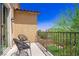 Relaxing balcony with seating and views of neighborhood landscaping under a bright sky at 7733 Harthill Park Ave, Las Vegas, NV 89113