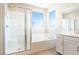 Bright bathroom showcasing a soaking tub and separate glass shower with white tiling at 7733 Harthill Park Ave, Las Vegas, NV 89113