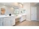 Bathroom featuring dual sinks with white cabinetry, ample counter space, and a large mirror at 7733 Harthill Park Ave, Las Vegas, NV 89113