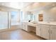 Bright bathroom featuring dual sinks, a soaking tub, and a separate glass-enclosed shower at 7733 Harthill Park Ave, Las Vegas, NV 89113