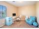 Bright bedroom featuring a desk, chair, and a unique blue accent chair and mini-fridge at 7733 Harthill Park Ave, Las Vegas, NV 89113
