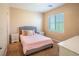Cozy bedroom with neutral walls, carpet, a comfortable bed, and a bright window at 7733 Harthill Park Ave, Las Vegas, NV 89113