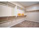 Walk-in closet featuring open shelving with wooden rods, offering ample storage space at 7733 Harthill Park Ave, Las Vegas, NV 89113