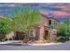 Two-story home featuring stone accents, a two-car garage, and a well-manicured front yard with mature trees at 7733 Harthill Park Ave, Las Vegas, NV 89113