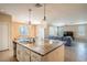 Open-concept kitchen and living room area with a large kitchen island and comfortable seating at 7733 Harthill Park Ave, Las Vegas, NV 89113