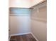 Compact walk-in closet with hanging rods and carpet flooring for efficient storage at 7733 Harthill Park Ave, Las Vegas, NV 89113