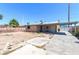 View of the home's backyard featuring a large dirt lot, patio cover, and extended driveway at 805 E Carey Ave, North Las Vegas, NV 89030
