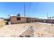 A backyard features a single story home, a fence, a dirt area, foliage, and utility lines overhead at 805 E Carey Ave, North Las Vegas, NV 89030