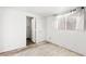 A simple bedroom features a window with white curtains, and a doorway to a bathroom or closet at 805 E Carey Ave, North Las Vegas, NV 89030