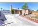 Exterior elevation of a single-story home with a concrete driveway and low-maintenance landscaping at 805 E Carey Ave, North Las Vegas, NV 89030