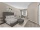 Bedroom featuring a grey upholstered bed, carpet, and a sitting area near the window at 8563 Red Diamond St, Las Vegas, NV 89123