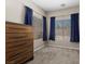 Bright bedroom with two large windows featuring blue curtains and a modern dresser at 8563 Red Diamond St, Las Vegas, NV 89123