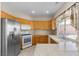 Well-lit kitchen features stainless appliances, wood cabinetry, granite countertops, and tile flooring at 8563 Red Diamond St, Las Vegas, NV 89123