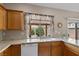 Kitchen sink features wood cabinetry, granite countertops, a view of the backyard, and tile flooring at 8563 Red Diamond St, Las Vegas, NV 89123