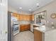 Well-lit kitchen features stainless appliances, wood cabinetry, granite countertops, and tile flooring at 8563 Red Diamond St, Las Vegas, NV 89123