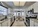 Spacious kitchen featuring white cabinets, stainless steel appliances, and a breakfast nook with natural lighting at 8808 Litchfield Ave, Las Vegas, NV 89134
