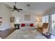 Cozy living room with hardwood floors, ceiling fan, large windows, and comfortable seating at 8808 Litchfield Ave, Las Vegas, NV 89134