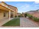 Paver patio and artificial grass accent this backyard with covered patio and mature landscaping at 8930 W Ford Ave, Las Vegas, NV 89148